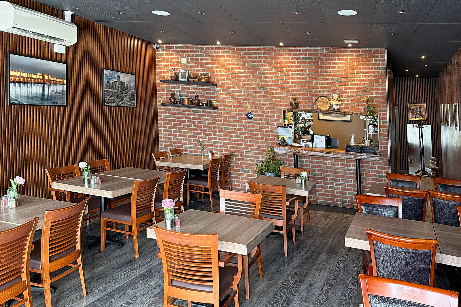 Avishan dining room in Langley with brick feature wall and wooden tables, set for a private event