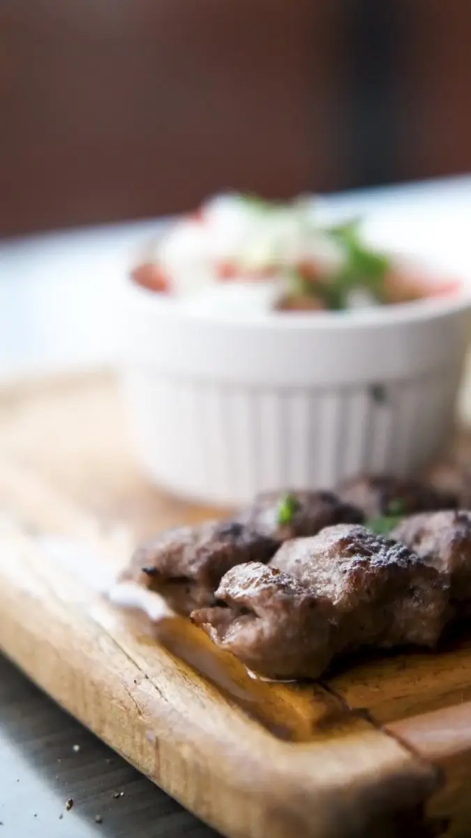 Barg kebab plated with saffron rice and grilled tomato