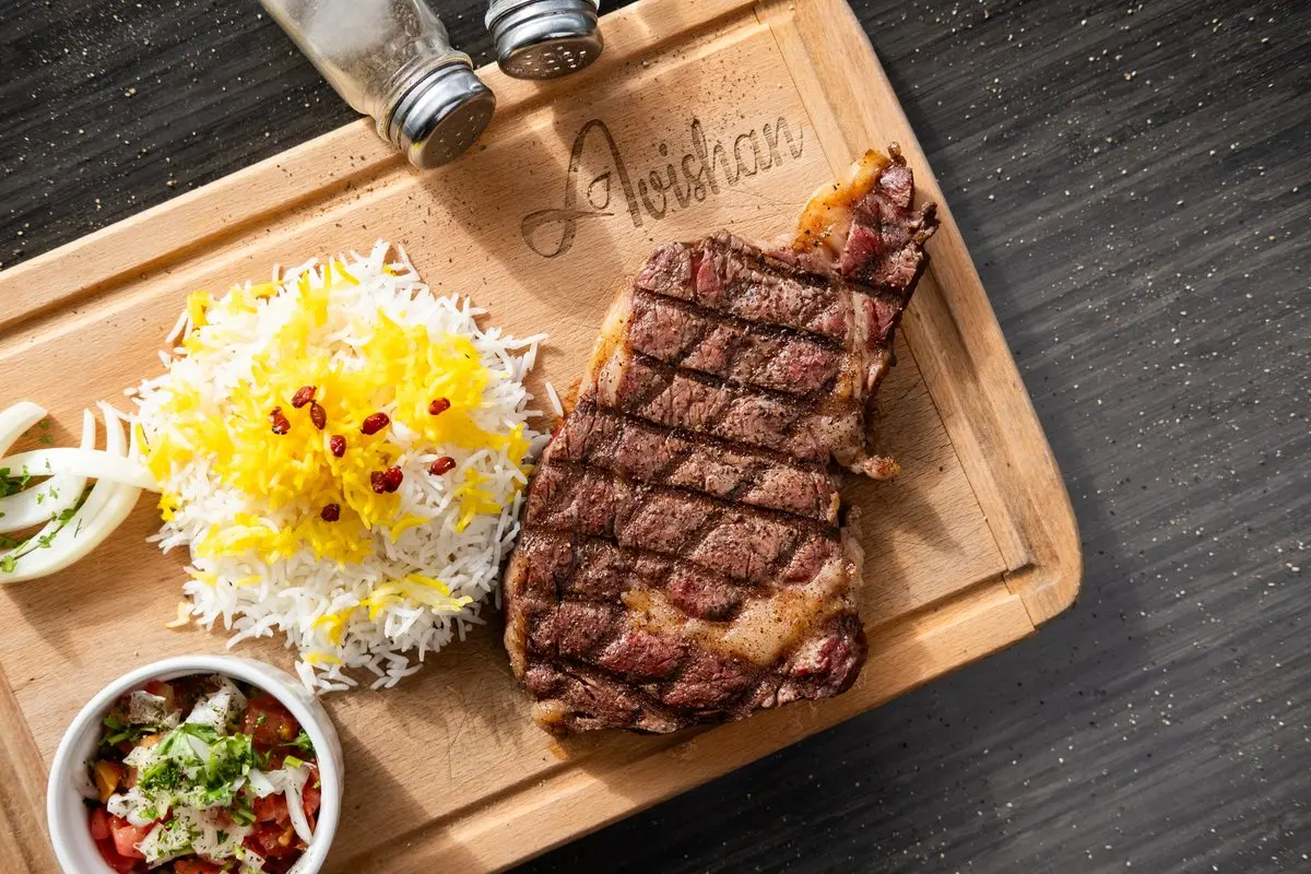 Grilled rib eye steak with saffron rice and salad