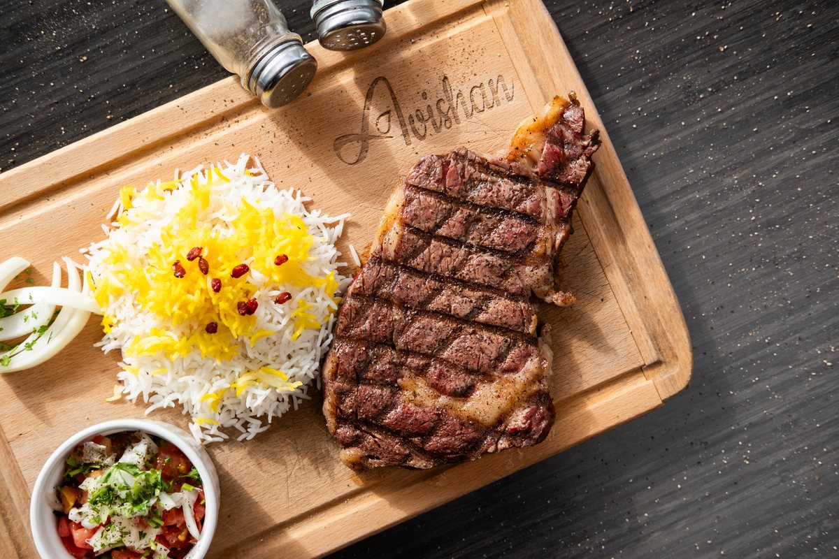 Grilled rib eye steak with saffron rice and salad