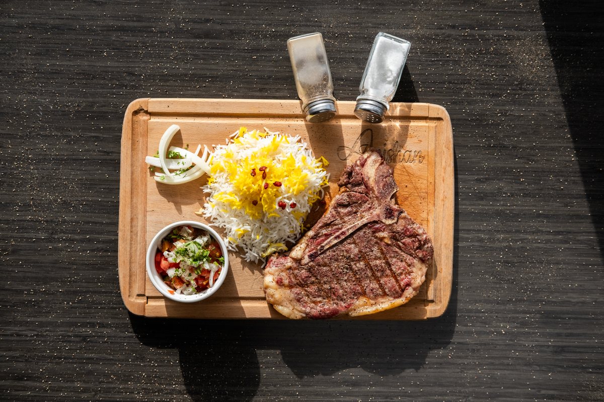 Grilled T-bone steak with saffron rice and salad