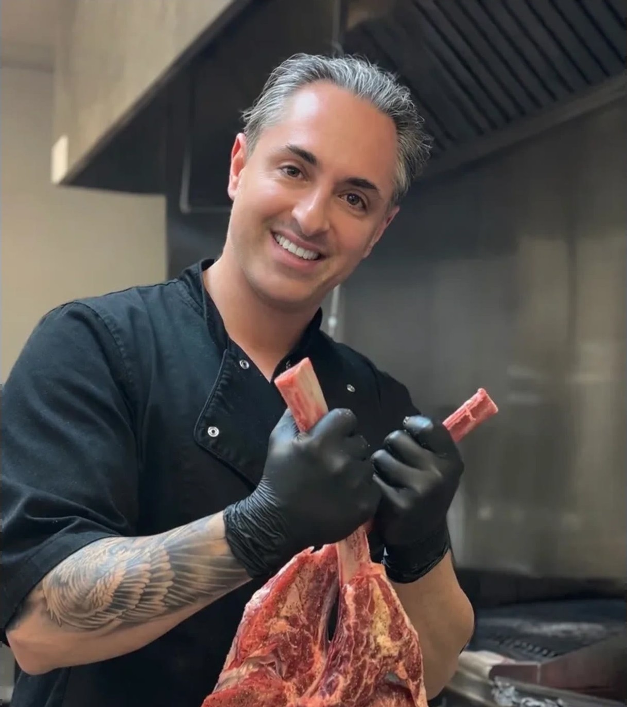 Chef Saman holding Avishan's Tomahawk steak